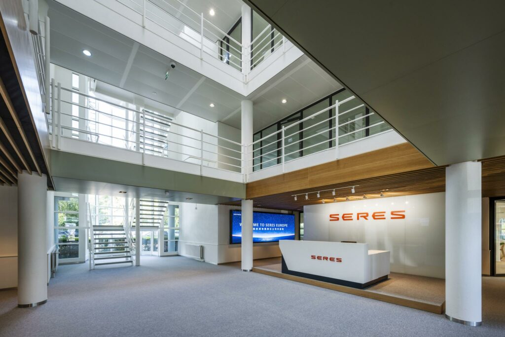 Moderne entreehal van het SERES-kantoor aan de Burgemeester Stramanweg met balie, vide en witte trappen.